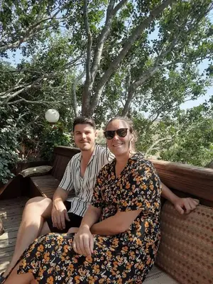 a man and a woman sitting on a bench at Green House in Zūbiyā