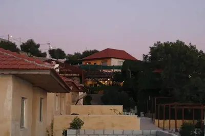 a group of buildings with a house in the background at Green House in Zūbiyā