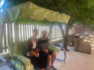 a man and a woman sitting on a bench at Green House in Zūbiyā