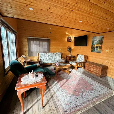 a living room with couches and a tv in a cabin at Green House in Zūbiyā
