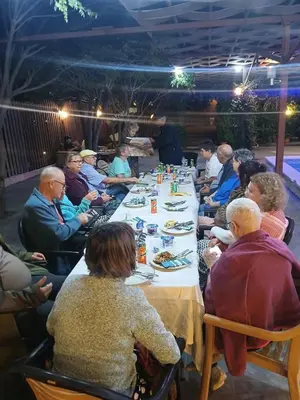 a group of people sitting at a long table at Green House in Zūbiyā