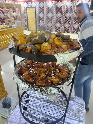 a man standing next to two trays of food at rum fun luxury camp in Wadi Rum