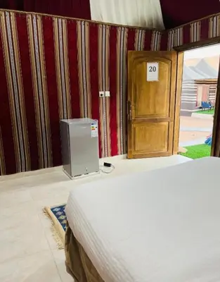 a bedroom with a bed and a wooden door at Maestro camp Wadi Rum in Wadi Rum