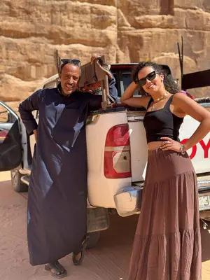 a man and a woman standing in front of a car at Serenity Camp in Wadi Rum