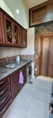 a kitchen with a sink and a washing machine at Khirfan Crown Houses -downtown in Amman