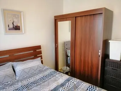 a bedroom with a bed and a wooden closet at Abdoun studio in Amman