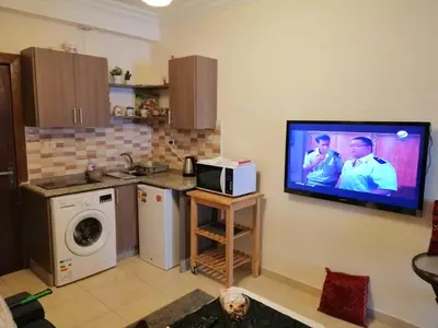 a kitchen with a tv hanging on the wall at Abdoun studio in Amman