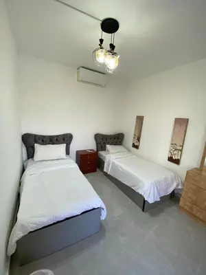 a bedroom with two beds and a chandelier at Tala bay apartments 2 bedroom for family only in Aqaba