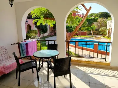 a patio with a table and chairs and a pool at Nice tow bedrooms by snake pool for families only in Talapay in Aqaba