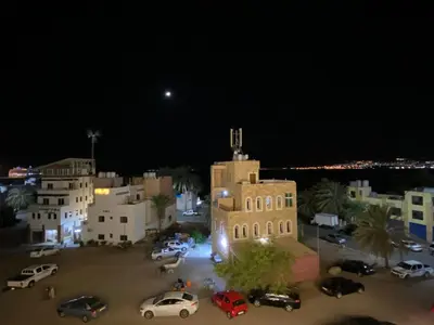 a group of cars parked in a parking lot at night at Golden View in Aqaba