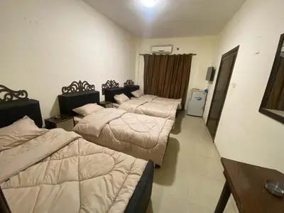 a hotel room with three beds and a television at Golden View in Aqaba