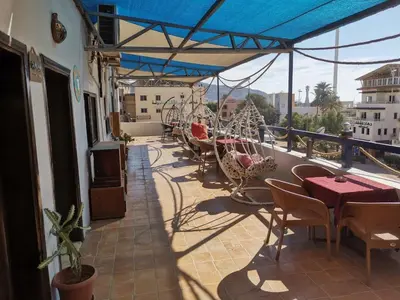 a balcony with tables and chairs on a building at Golden View in Aqaba
