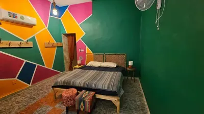 a bedroom with a bed and a colorful wall at Mango Haus in Aqaba