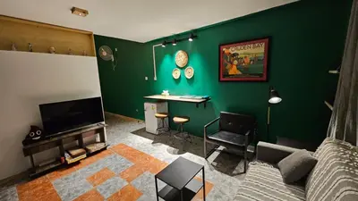 a living room with a green wall at Mango Haus in Aqaba
