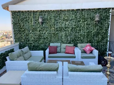 a green wall with couches and pillows on a balcony at The view II in Amman