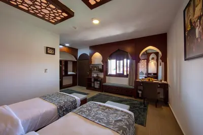 a hotel room with two beds and a desk at Petra Seasons luxury Resort in Al Ḩayy