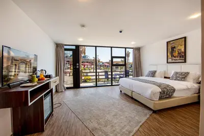 a bedroom with a large bed and a flat screen tv at Petra Seasons luxury Resort in Al Ḩayy