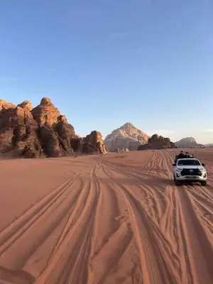 a car driving through the desert at Wadi rum stay in Wadi Rum