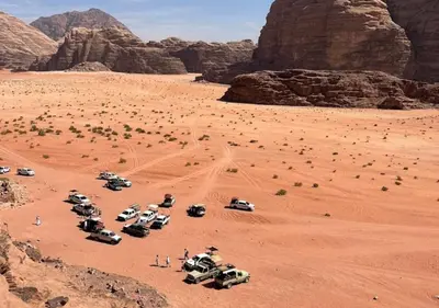 a group of vehicles parked in the desert at Wadi rum stay in Wadi Rum