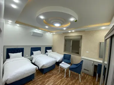 a hotel room with two beds and a table and chairs at Treasury Terrace Apartments in Wadi Musa