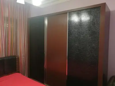 a bedroom with a large wooden closet with a red bed at Dream Home in Amman