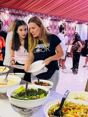 two women standing in front of a buffet of food at Al Raha Luxury Camp in Wadi Rum