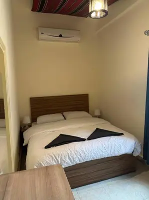 a bedroom with a bed with a wooden head board at Antica old apartment al-lwebdeh in Amman