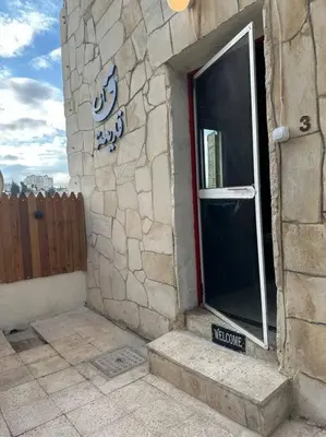 a stone building with a door and a window at Antica old apartment al-lwebdeh in Amman