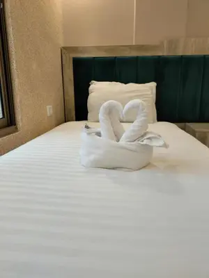 two swans made out of towels sitting on a bed at Old Street Apartment in Wadi Musa