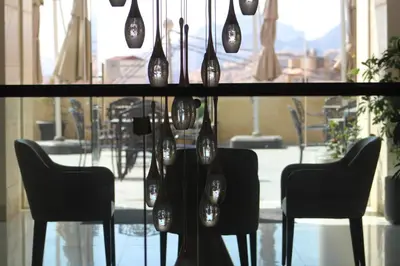 a glass table with chairs and wine bottles on it at H Luxury Hotel in Wadi Musa