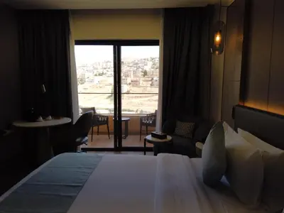 a hotel room with a bed and a large window at H Luxury Hotel in Wadi Musa