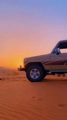 a truck in the desert with the sunset in the background at Adel Wadi Rum Camp Bubble in Wadi Rum