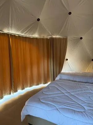 a bedroom with a white bed in a tent at Wadi Rum stael Luxury Camp in Wadi Rum