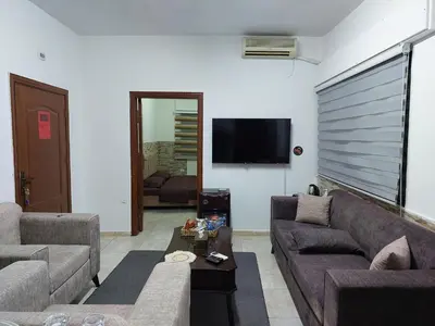 a living room with two couches and a flat screen tv at Cozy Home 3 in Amman