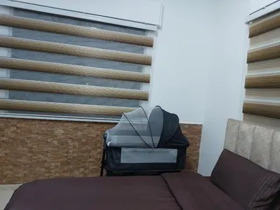a bedroom with a bed and a couch and a window at Cozy Home 3 in Amman