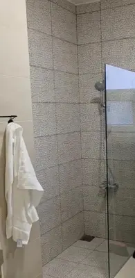 a bathroom with a shower with a glass door at Amman Business Park Apartment in Amman