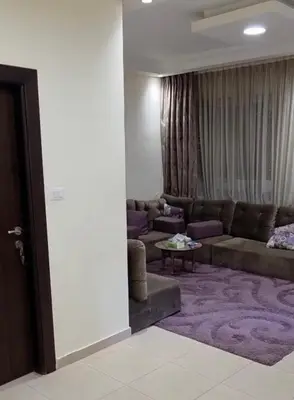 a living room with a couch and a table at Amman Business Park Apartment in Amman