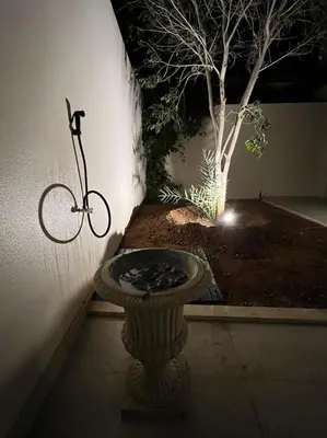 a bike is parked next to a wall with a light at Zerø Føur DeadSea in Sowayma
