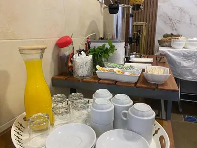 a table with plates and cups and a vase at Petra Oleander Hotel in Wadi Musa