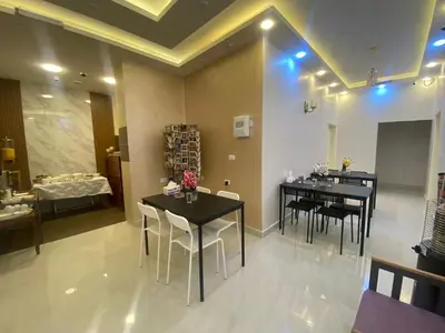 a dining room with two tables and chairs and a couch at Petra Oleander Hotel in Wadi Musa