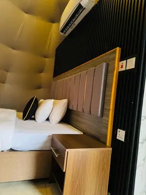 a bedroom with a bed with a headboard and pillows at Mira Bubble Luxury Camp in Wadi Rum