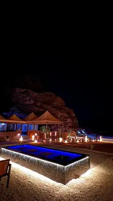 a swimming pool at night with a building at Mira Bubble Luxury Camp in Wadi Rum