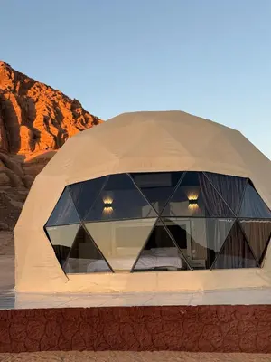 a domed building with glass windows in the desert at Wadi rum sky luxury in Wadi Rum