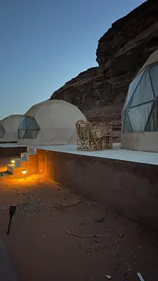 a couple of domes with chairs and tables in the desert at Rum New Luxury Camp in Wadi Rum