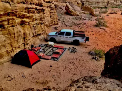a white truck parked in the desert with a tent at Bedouin oasis in Wadi Rum