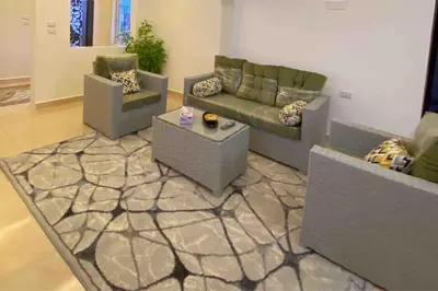 a living room with two couches and a rug at بيت العُمري (ام قيس) in Um Qeis