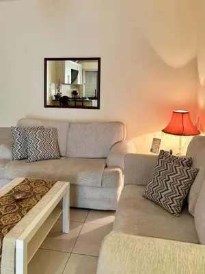 a living room with two couches and a mirror at Exquisite & inviting 2 Bedroom 2 bath Balcony Fast internet in Amman