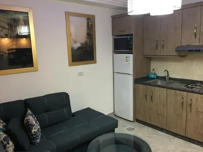 a living room with a couch and a kitchen at The Royal Luxury Queen Terrace 1 in Amman