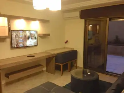 a room with a desk and a bench and a window at The Royal Luxury Queen Terrace 1 in Amman