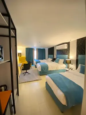 a hotel room with two beds and a desk at The RN Hotels in Wadi Musa